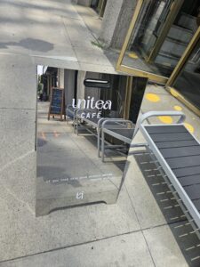 UniTea's mirrored folding sign on the sidewalk. Photograph by Drew Saunders.