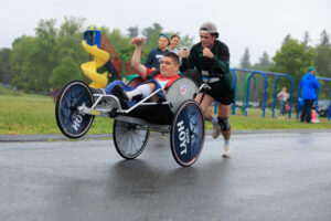 Massachusetts AdaptX Unified 5K inclusive road race man pushing brother in wheelchair